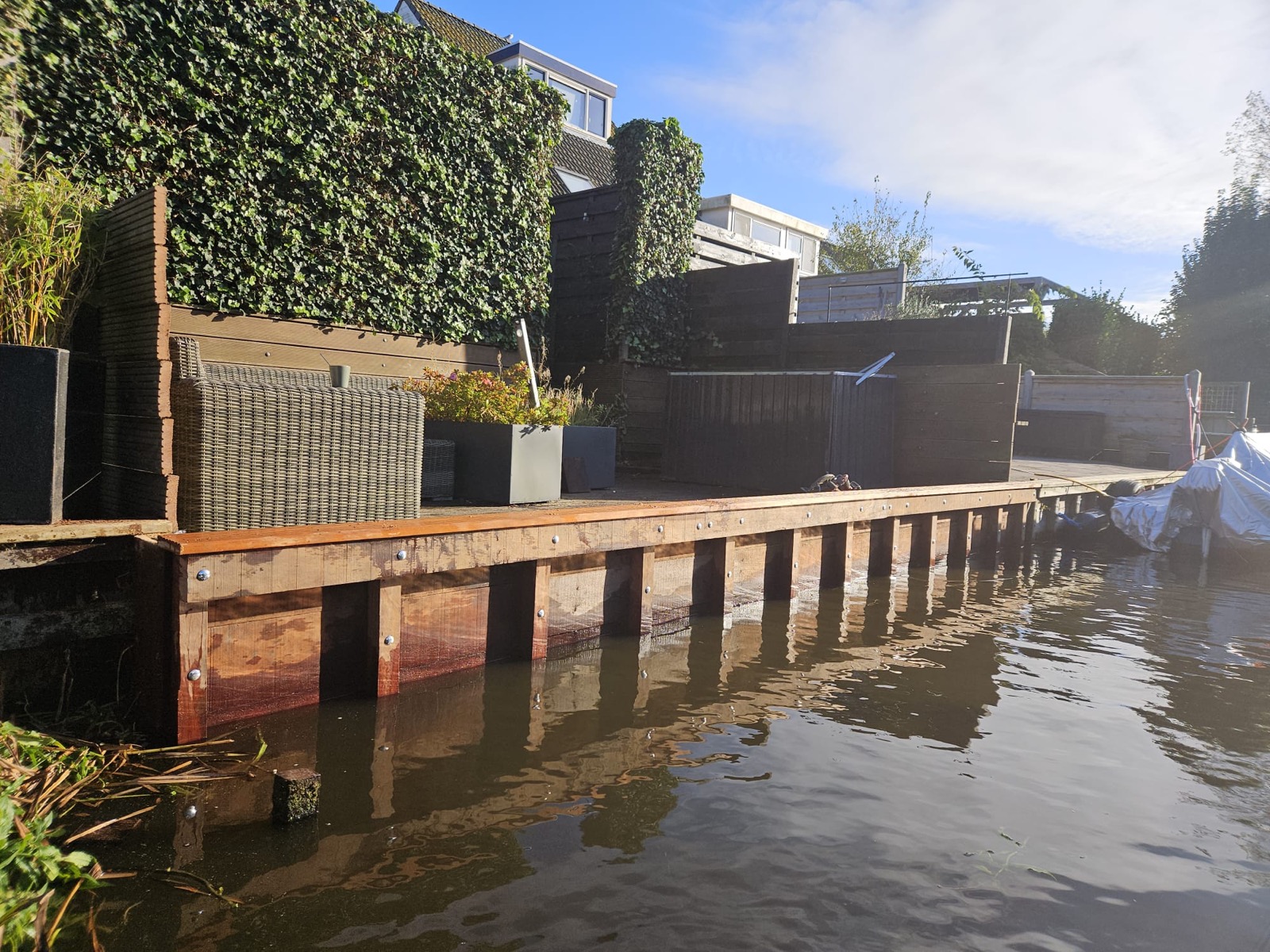 Professionele houten beschoeiing aan het water met tuin in Noord-Holland